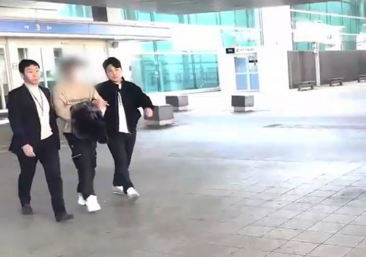 중국 기반 보이스피싱 조직 총책 A씨가 인천공항에서 체포돼 경찰차로 이동하고 있다. 경기북부경찰청 제공