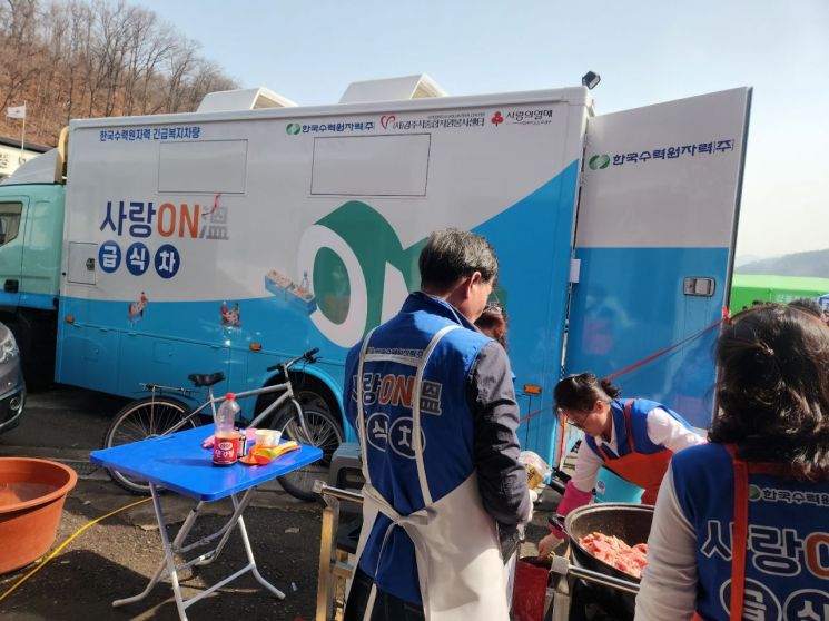 한국수력원자력(주)에서 24일 경북 사랑의열매를 통해 지원한 급식차량을 활용, 산불 현장에서 자원봉사자들이 급식 지원을 하고 있다.