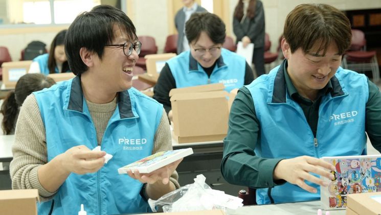 프리드라이프 임직원들이 발달장애인 미술 작가의 작품을 활용한 '봄맞이 선물 키트'를 제작하고 있다. 프리드라이프 제공