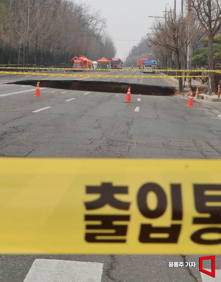 지난 24일 서울 강동구 대명초등학교 인근 사거리에서 4개차로에 걸친 '대형 싱크홀(땅꺼짐)' 이 발생했다. 25일 사고 현장 주변이 통제되고 있다. 싱크홀에는 승용차 1대와 오토바이 1대가 빠졌으며, 승용차 탑승자 1명은 인근 병원으로 이송됐다. 현재 싱크홀 아래에는 오토바이 운전자 1명이 매몰돼 있다. 깊이는 30m로 추정된다. 2025. 03. 25 윤동주 기자