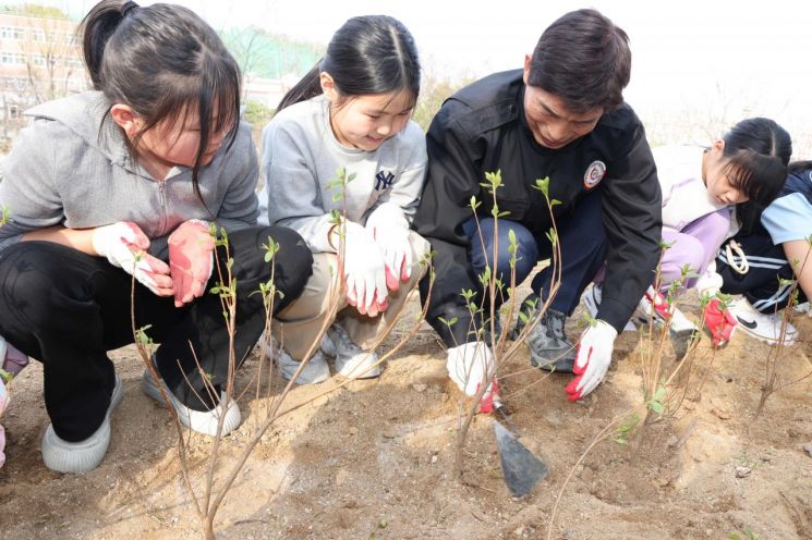 대구 달서구에서 어린이들과 함께 '기억의 나무'를 심고 있다.