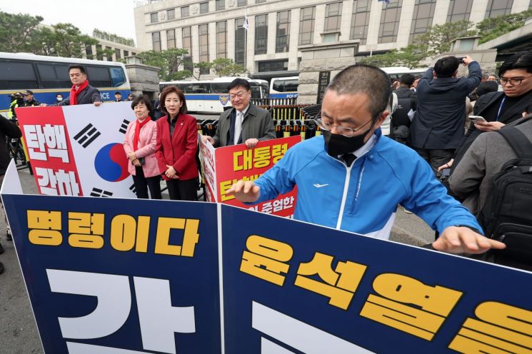 25일 서울 종로구 헌법재판소 앞에서 윤석열 대통령 탄핵 반대 피케팅 하던 나경원, 정점식 국민의힘  의원이 박홍배 더불어민주당 의원의 윤 대통령 파면을 촉구하는 피케팅 준비하는 모습을 바라보고 있다. 연합뉴스