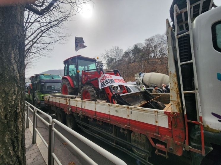 전국농민회총연맹이 25일 오후 2시 서울 서초구 남태령역 4호선 2번출구 인근에서 연 윤석열 대통령 탄핵 촉구 집회에서 트럭에 트랙터를 실은 채 행진하고 있다. 변선진 기자