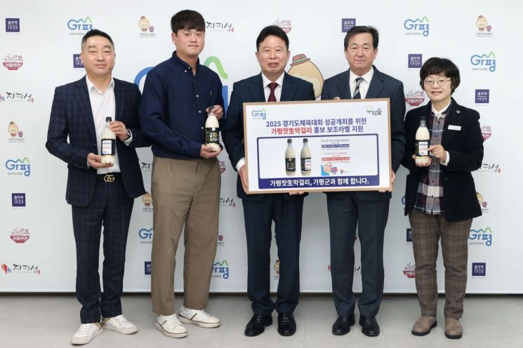 서태원 가평군수(가운데)가 지난 25일 ‘제15회 경기도장애인체육대회’와 ‘제71회 경기도체육대회’의 성공 개최를 기원하며 ㈜우리술과 홍보 보조라벨 전달식을 갖고 있다. 가평군 제공