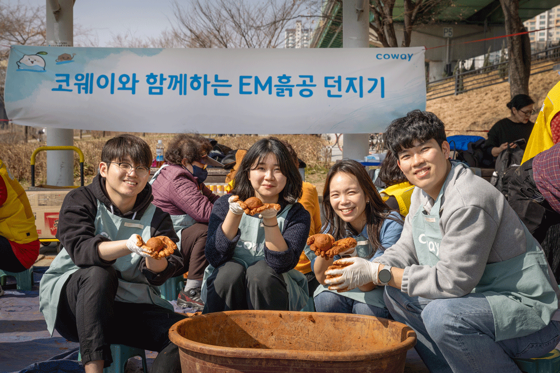 코웨이 임직원 봉사자가 안양천 다목적광장에서 EM 흙공을 제작하고 있다. 코웨이 제공