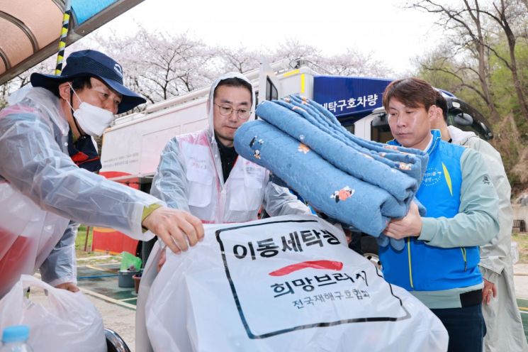 희망브리지 관계자와 봉사자가 광명사랑의집에서 세탁을 마친 침구를 정리하고 있다. 희망브리지