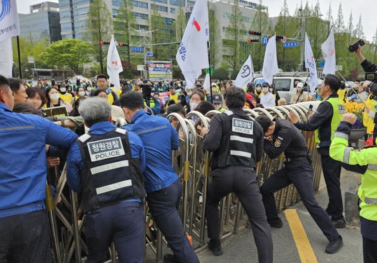 경남도청 청원경찰들이 집회 참가자들이 미는 철제 울타리가 넘어지지 않게 지탱하고 있다. 이세령 기자