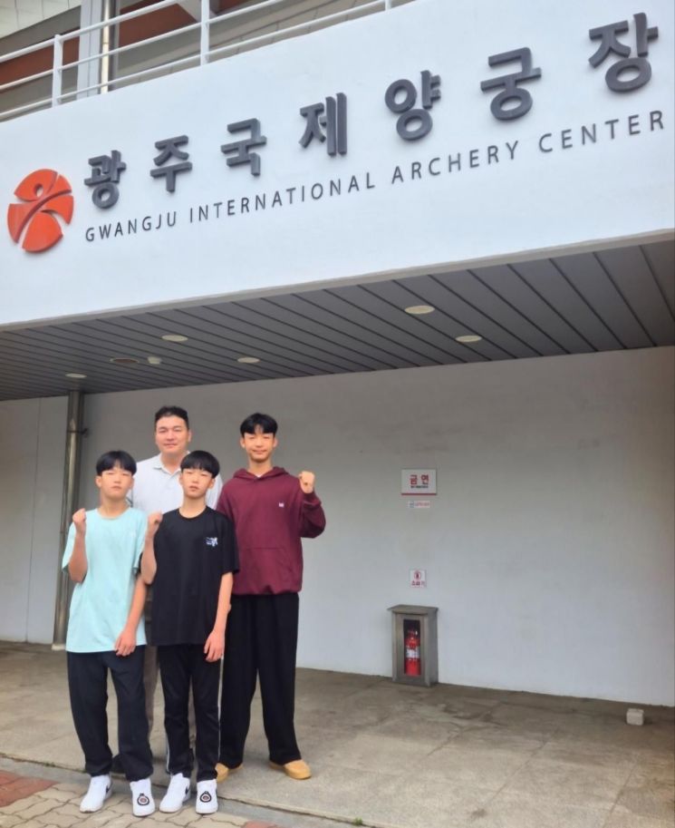 광주국제양궁장 앞에서 전국소년체전 출전을 앞둔 조여준 군과 쌍둥이 동생 조유준·조담준 군이 아버지 조세영 씨와 함께 기념촬영을 하고 있다. 광주교육청 제공