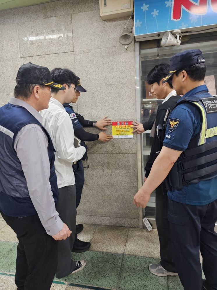 광주 금남로 지하상가에서 경찰과 상인회가 무단 전기 사용 방지를 위한 경고문을 부착하고 있다. 광주경찰청 제공