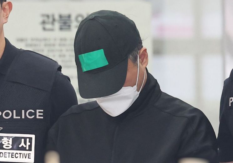 부모와 처자식 등 일가족 5명을 살해한 50대 가장 A씨가 24일 경기도 용인동부경찰서 유치장에서 검찰로 송치되고 있다. 연합뉴스