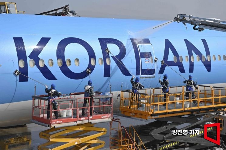 인천 중구 대한항공 항공기 정비고에서 대한항공 관계자들이 새로운 CI가 적용된 항공기 동체를 세척하고 있다. 강진형 기자