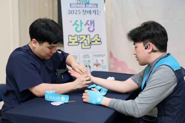 광주 광산구 찾아가는 상생보건소에서 집배 노동자가 체형 교정 테이핑 서비스를 받고 있다. 광산구 제공
