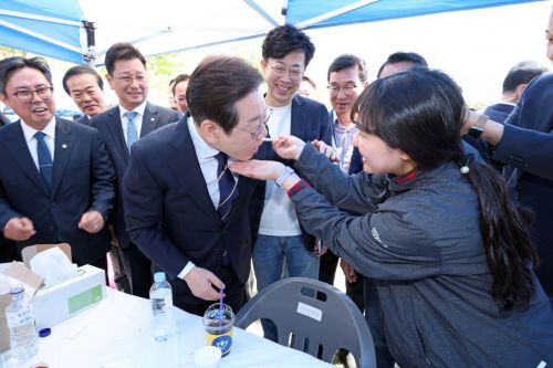 더불어민주당 대선 예비후보 이재명 전 대표가 26일 광주 광산구 호남대학교에서 열린 광주전남기자협회 체육대회를 찾아 한 참석자가 건넨 김치를 맛보고 있다. 연합뉴스