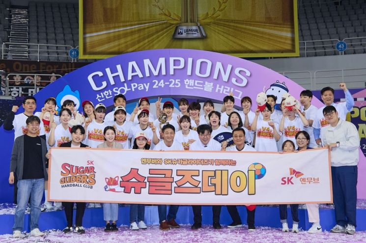 김원기 SK엔무브 사장(첫줄 왼쪽 다섯번째)이 임직원들과 27일 서울 송파구 올림픽공원 핸드볼경기장에서 열린 '2024-2025 핸드볼 H리그 여자부 챔피언결정전 2차전 경기'에 참석해 통합 우승을 차지한 SK슈가글라이더즈 선수단과 함께 우승 트로피를 들고 기념촬영을 하고 있다. SK이노베이션
