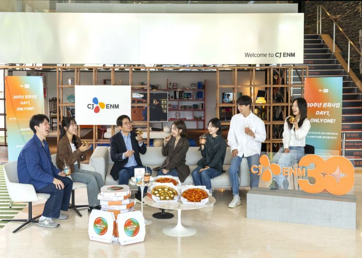 윤상현 CJ ENM 대표(왼쪽 세번째)가 CJ 문화사업 출범일(1995년 4월 28일)을 기념해 직원들과 피자를 먹으며 창업정신을 되새기는 ‘DAY1 미팅’을 진행하고 있다. CJ ENM 제공