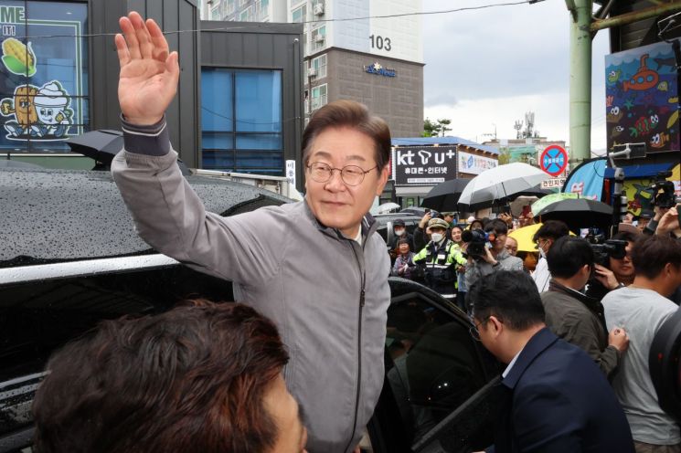 더불어민주당 이재명 대선 후보가 '골목골목 경청투어' 사흘째인 3일 '동해안벨트' 첫 방문지인 강원도 속초시 중앙재래시장에서 강원도민들을 만난 뒤 차에 올라 인사하고 있다. 연합뉴스
