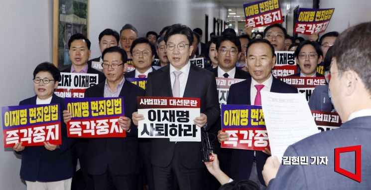 국민의힘 의원들이 7일 국회 법제사법위원회 전체회의장 앞에서 ‘이재명 면죄입법 즉각중지’ 등의 내용이 적힌 손팻말을 들고 구호를 외치고 있다. 2025.5.7 김현민 기자