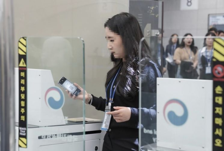 지난 8일 오후 경남 김해국제공항 검역소에서 한 시민이 질병관리청이 시범운영 중인 '큐코드 기반 페이퍼리스 검역'을 체험하고 있다. 질병관리청