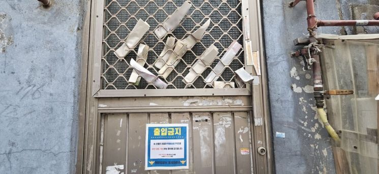 서울 종로구 충신동 충신1구역에 위치한 한 빈집 출입문 틈새에 공과금 고지서가 끼어있다. 출입문에는 무단 침입을 금지한다는 내용의 안내문이 붙어있다. 이지은 기자