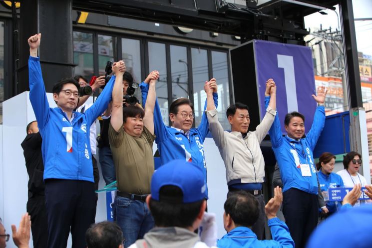 이재명 후보가 김경수 전 경남지사(가장 왼쪽), 송순호 경남도당 위원장(가장 오른쪽), 지지 발언자들과 함께 잡은 손을 들어보이고 있다. 이세령 기자