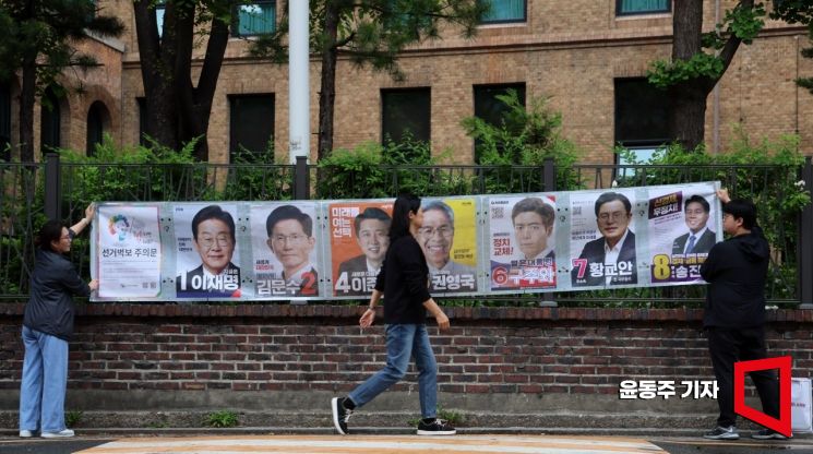 15일 서울 종로구 예술가의집 인근 담에 서울시 선관위 관계자들이 제21대 대통령선거 후보자 선거벽부를 붙이고 있다. 2025.05.15 윤동주 기자