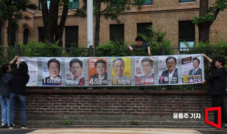 15일 서울 종로구 예술가의집 인근 담에 서울시 선관위 관계자들이 제21대 대통령선거 후보자 선거벽부를 붙이고 있다. 2025.05.15 윤동주 기자