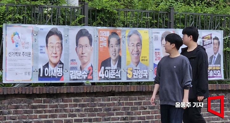 15일 서울 종로구 예술가의집 인근 담에 서울시 선관위 관계자들이 제21대 대통령선거 후보자 선거벽부를 붙이고 있다. 2025.05.15 윤동주 기자