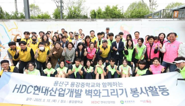 박희영 용산구청장과 HDC현대산업개발 직원, 지역 청소년들이 벽화그리기 봉사활동에 참여한 후 기념촬영을 하고 있다. 용산구 제공.
