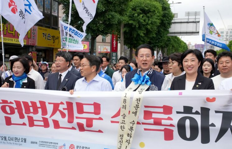 김영록 전라남도지사를 비롯한 강기정 광주광역시장 등 시민들이 17일 오후 광주 동구 금남로에서 5·18 전야제 행사 중 하나인 민주평화대행진을 펼치고 있다. 전남도 제공