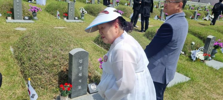 18일 오전 광주 북구 운정동 국립 5·18민주묘지에서 김순자(72)씨가 남편 고 김영철 열사의 묘역을 참배하고 있다.