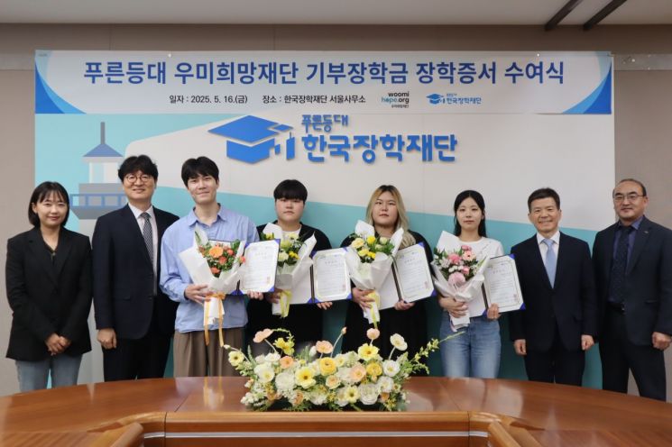 이춘석 우미희망재단 사무국장(왼쪽 두 번째)이 지난 16일 서울 중구 한국장학재단 서울사무소에서 고영종 한국장학재단 성장(오른쪽 두번째), 대표 장학생들과 함께 기념 촬영을 하고 있다. 우미희망재단 제공