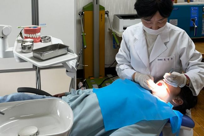 광주 서구가 운영 중인 '찾아가는 초등학교 구강보건실'에서 치과의사가 초등학생에게 구강검진을 실시하고 있다. 광주 서구 제공