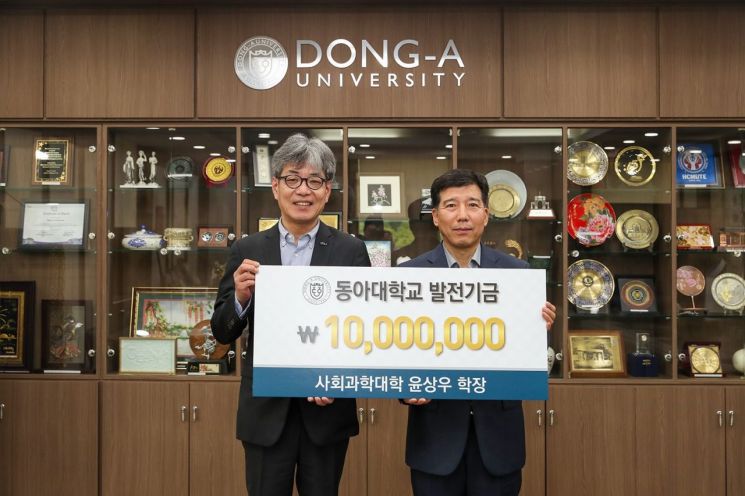 동아대 윤상우 사회과학대학장이 학교발전기금 1000만원을 기부하고 있다.