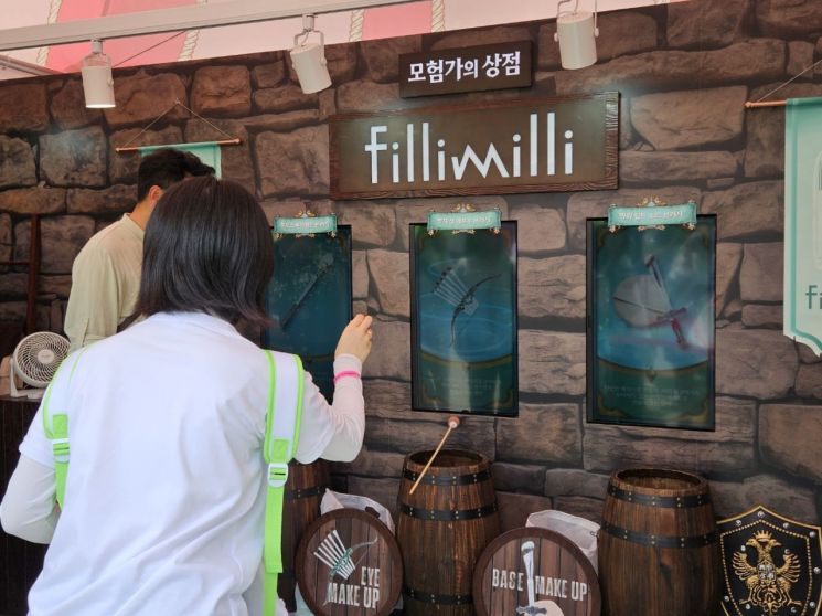 메이크업존 '필리밀리' 부스(왼쪽)와 '에스쁘아' 부스에서 참가자가 이벤트에 참여하고 있다. 사진=박재현 기자·연합뉴스