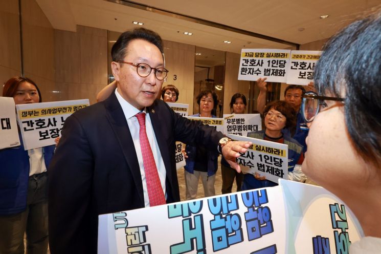 박민수 보건복지부 제2차관이 21일 서울 용산구 피크앤파크컨벤션에서 열린 '간호법 제정에 따른 진료지원업무 제도화 방안 공청회'에 참석하던 중 박 차관을 기다리며 피케팅하는 전국민주노동조합총연맹 공공운수노조 의료연대본부 조합원들을 만나 대화하고 있다. 연합뉴스