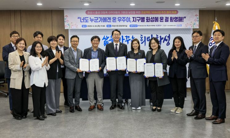 미등록 이주아동 기본권 보장을 위한 '프로젝트 169' 협약식에서 정명근 화성시장 등 참석자들이 협약서를 들어보이고 있다. 화성시 제공
