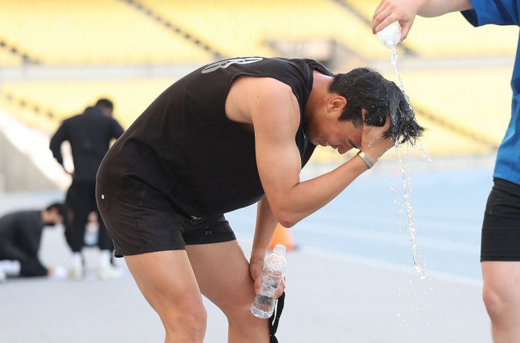 대구 낮 최고기온이 33.4도까지 오른 20일 대구스타디움에서 열린 대구시 재난안전기동대 채용 체력 검정을 마친 한 응시자가 시원한 물로 세수하고 있다. 2025.5.20 연합뉴스
