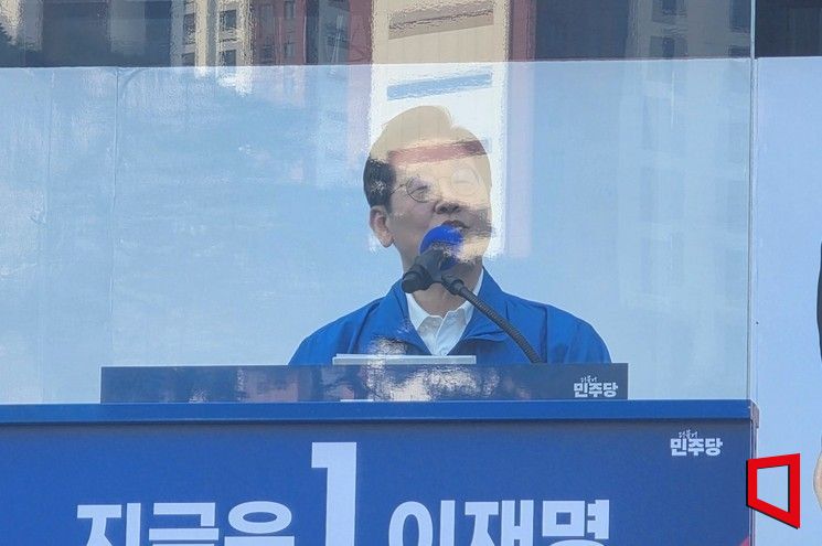 민주당 이재명 후보가 25일 판막 뒤에서 연설하고 있다.