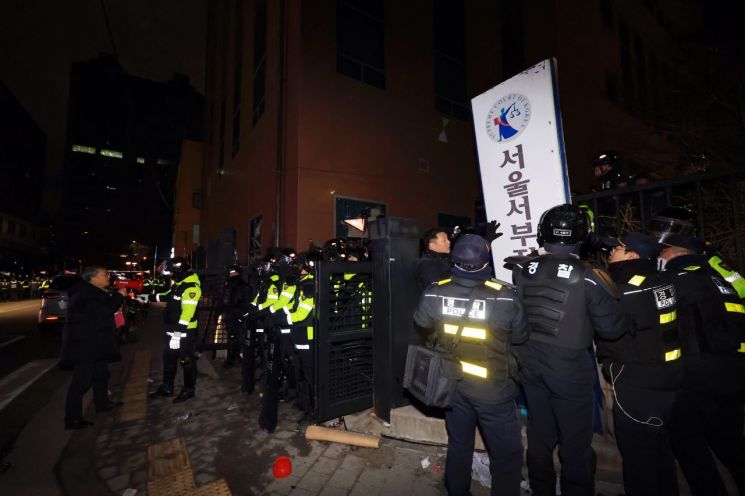 서부지법 폭동 당시 경찰이 법원 후문에 쓰러진 현판을 세우고 있다. 연합뉴스