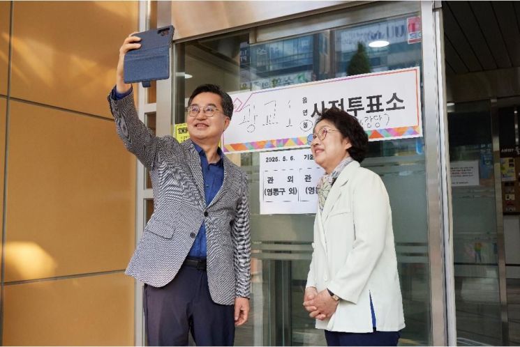 김동연 경기도지사가 제21대 대통령선거 사전투표 첫날인 29일 오전 7시께 도청사 인근 수원시 영통구 광교1동행정복지센터에 마련된 투표소에서 배우자 정우영 씨와 함께 한표를 행사한 뒤 사진을 찍고 있다. 경기도 제공