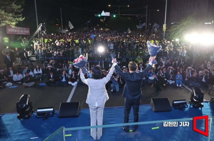 제21대 대통령 선거 이튿날인 4일 이재명 더불어민주당 대선 후보가 당선이 확실시되자 서울 여의도 국회 앞에 마련된 무대를 찾아 당선 수락연설에 앞서 아내 김혜경 여사와 인사하고 있다. 2025.6.4 김현민 기자