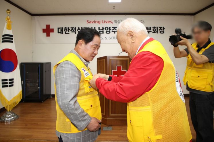 주광덕 남양주시장(왼쪽)이 대한적십자사봉사회 남양주시협의회 명예지부장 명찰을 받고 있다. 남양주시 제공