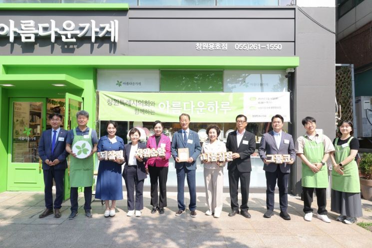손태화 의장(가운데)을 비롯한 경남 창원시의회 의원과 직원들이 아름다운가게에 물품을 기탁하고 가게 관계자들과 기념사진을 찍고 있다. 창원시의회 제공