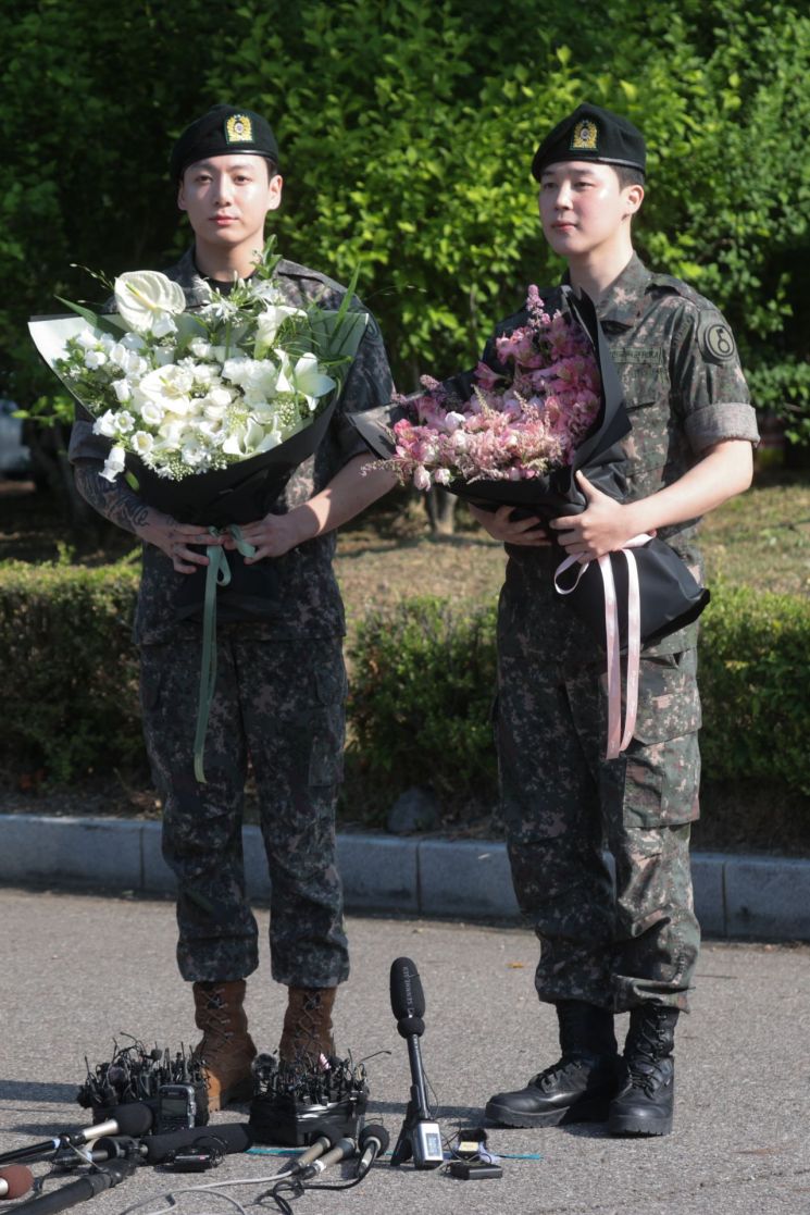 육군 현역 복무를 마치고 만기 전역한 그룹 방탄소년단(BTS)의 지민과 정국이 11일 경기도 연천군 연천공설운동장에서 팬들과 취재진을 향해 인사하고 있다. 연합뉴스