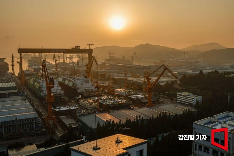 경남 거제 한화오션 옥포조선소 야드 도크에서 건조중인 액화천연가스(LNG) 운반선 위로 붉은 태양이 떠오르고 있다. 강진형 기자