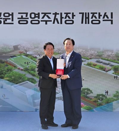 우오현 SM그룹 회장(오른쪽)이 12일 서울 서대문구 독립문문화공원 공영주차장 개장식에서 이성헌 서대문구청장으로부터 감사패를 받으며 기념촬영을 하고 있다. SM그룹.