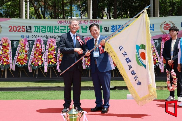 2025 재경예천군민의 날 행사 회장 이,취임식에서 예천군민의 기를 이임회장이 취임회장에게 건네주고 있다.