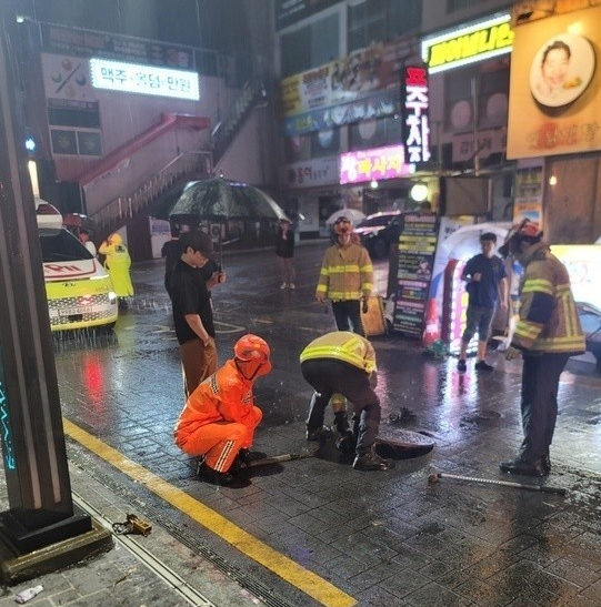 14일 오전 2시 33분쯤 부산 연제구 연산동에 닫혀있지 않던 맨홀 구멍에 대해 소방이 안전조치를 취하고 있다. 부산소방재난본부