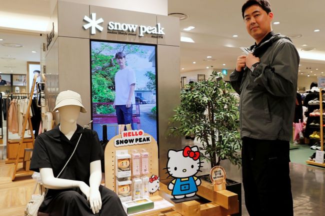 광주신세계 본관 7층 스노우피크에서 직원이 일상과 캠핑에서 활용하기 좋은 루트 스탠드넥 바람막이를 입고 포즈를 취하고 있다. 광주신세계 제공