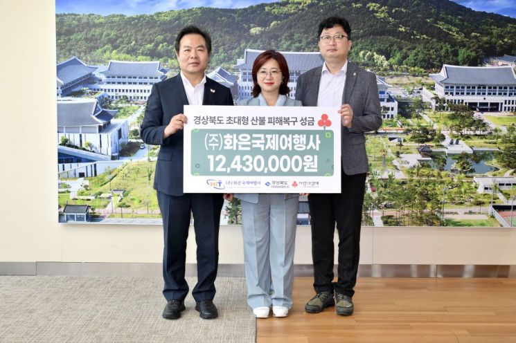 경북도 국외전담여행사로 지정된 화은국제여행사 이지언 대표(중앙)가 경북도에 산불성금 1243만원을 기탁한 뒤 김학홍 경북도 행정부지사(왼쪽)와 기념촬영을 하고 있다.